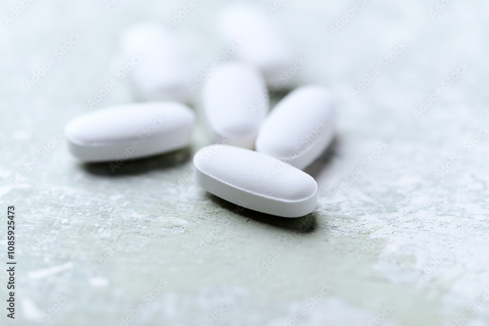 White tablets on wooden background. Soft focus. Close up. Copy space White tablets on wooden background. Soft focus. Close up. Copy space