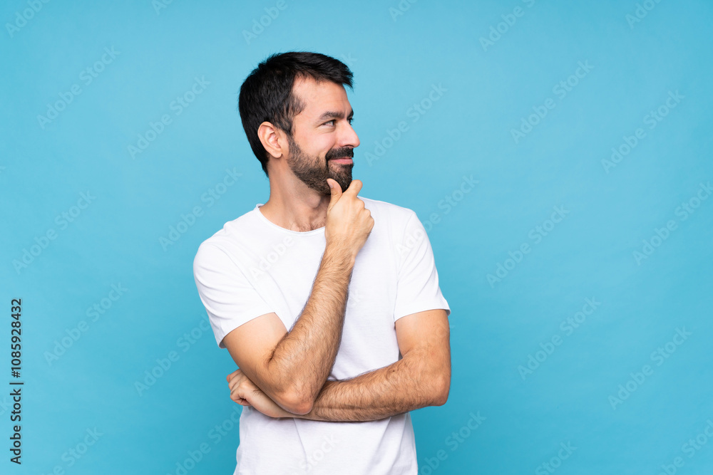 Young man with beard over isolated blue background looking to the side Young man with beard over isolated blue background looking to the side