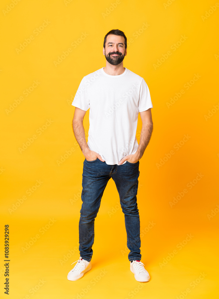 Full-length shot of man with beard over isolated yellow background laughing Full-length shot of man with beard over isolated yellow background laughing