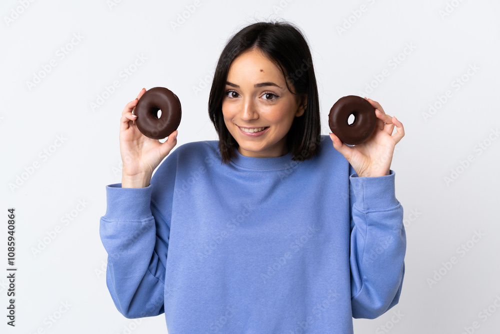 Fototapeta premium Young caucasian woman isolated on white background holding donuts