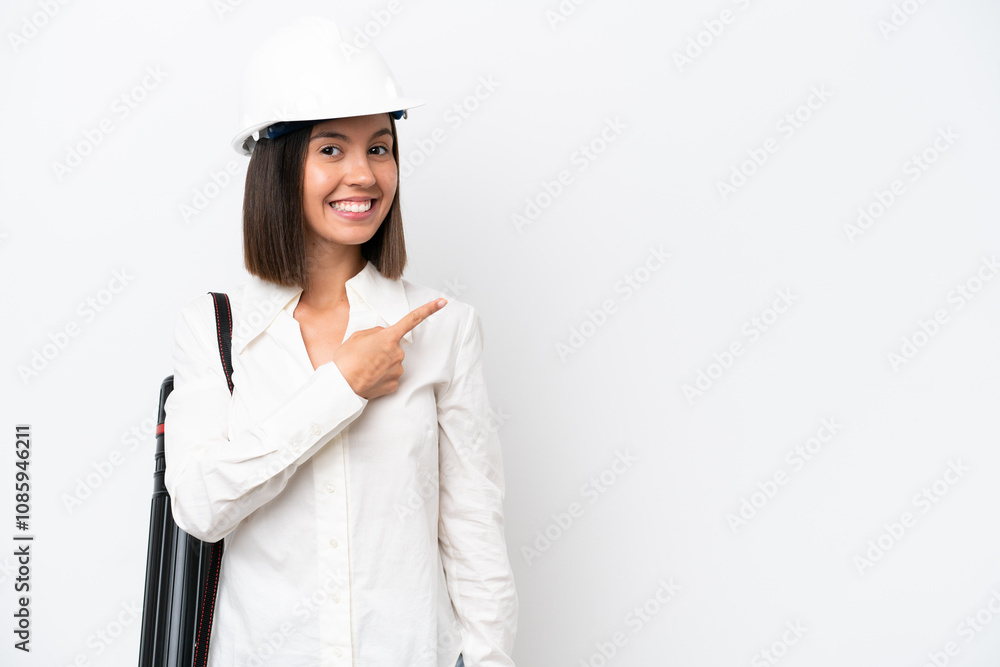 Young architect woman with helmet and holding blueprints isolated on white background pointing to the side to present a product Young architect woman with helmet and holding blueprints isolated on white background pointing to the side to present a product