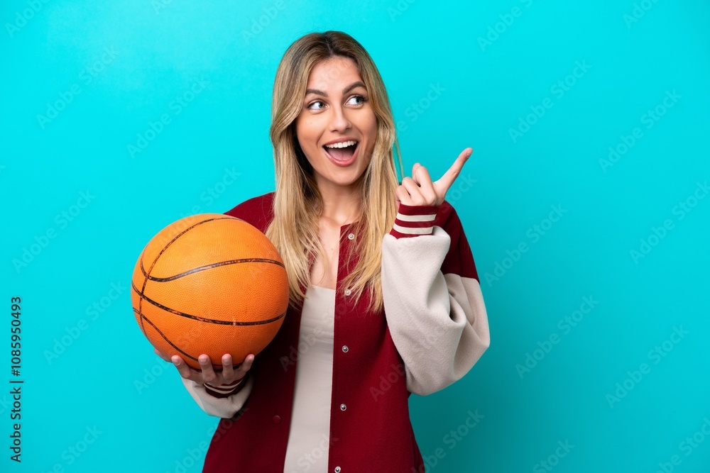 Young caucasian basketball player woman isolated on blue background intending to realizes the solution while lifting a finger up