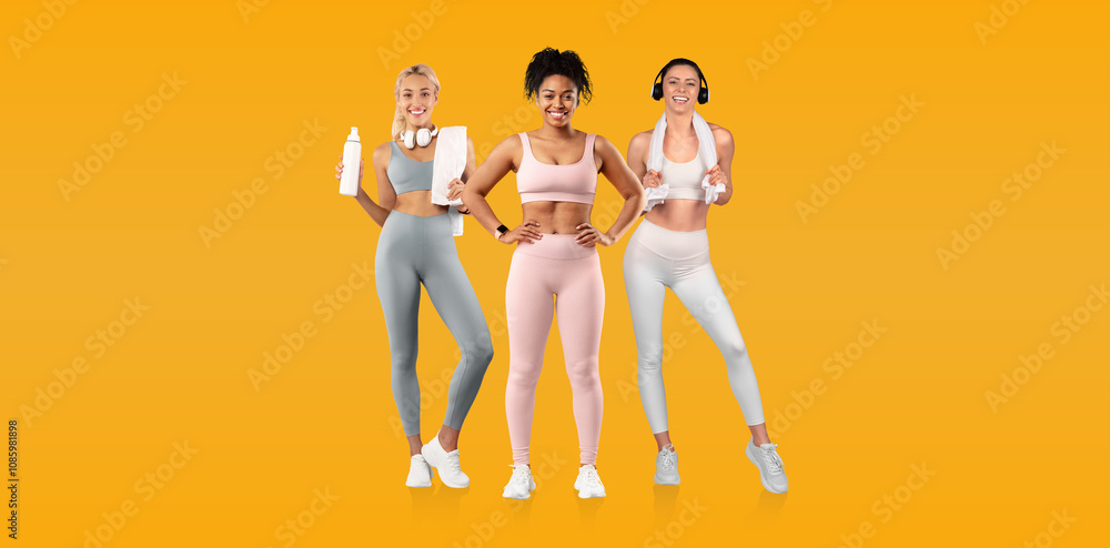 © Prostock-studio - Three women dressed in colorful activewear stand together, each holding water bottles, smiling brightly. The vibrant yellow backdrop enhances their energetic vibe. © Prostock-studio - Three women dressed in colorful activewear stand together, each holding water bottles, smiling brightly. The vibrant yellow backdrop enhances their energetic vibe.
