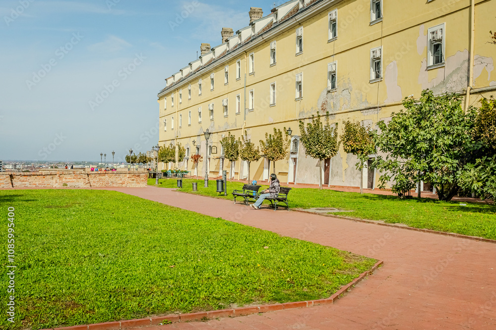 Obraz premium The fortress perched on Petrovaradin Hill watches over the city, while the charming streets and modern buildings of Novi Sad are spread out, creating a perfect blend of history and contemporary life