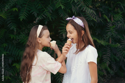 Two Happy Girls Eating Ice Cream Together Outdoors photo