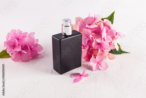 Elegant black perfume bottle with vibrant pink hydrangeas photo