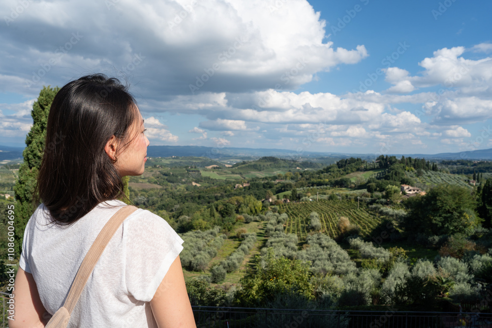 Woman admiring scenic Tuscany view near San Gimignano