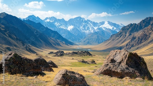 Rocky pass Karatyurek with sparse vegetation and snow islands in the Altai mountains. Mountain peaks in a blue haze. photo