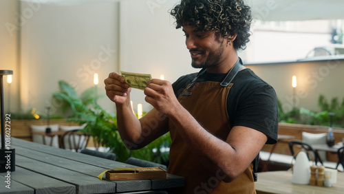 Foto Happy Indian Arabian man guy male waiter cafe worker cleaner small business owne