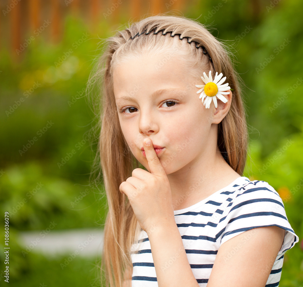 Little girl has put forefinger to lips as sign of silence Little girl has put forefinger to lips as sign of silence