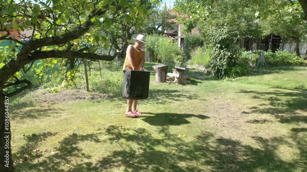 Farmer boy cutting grass with lawnmower in sustainable organic garden. Farmer boy cutting grass with lawnmower in sustainable organic garden.