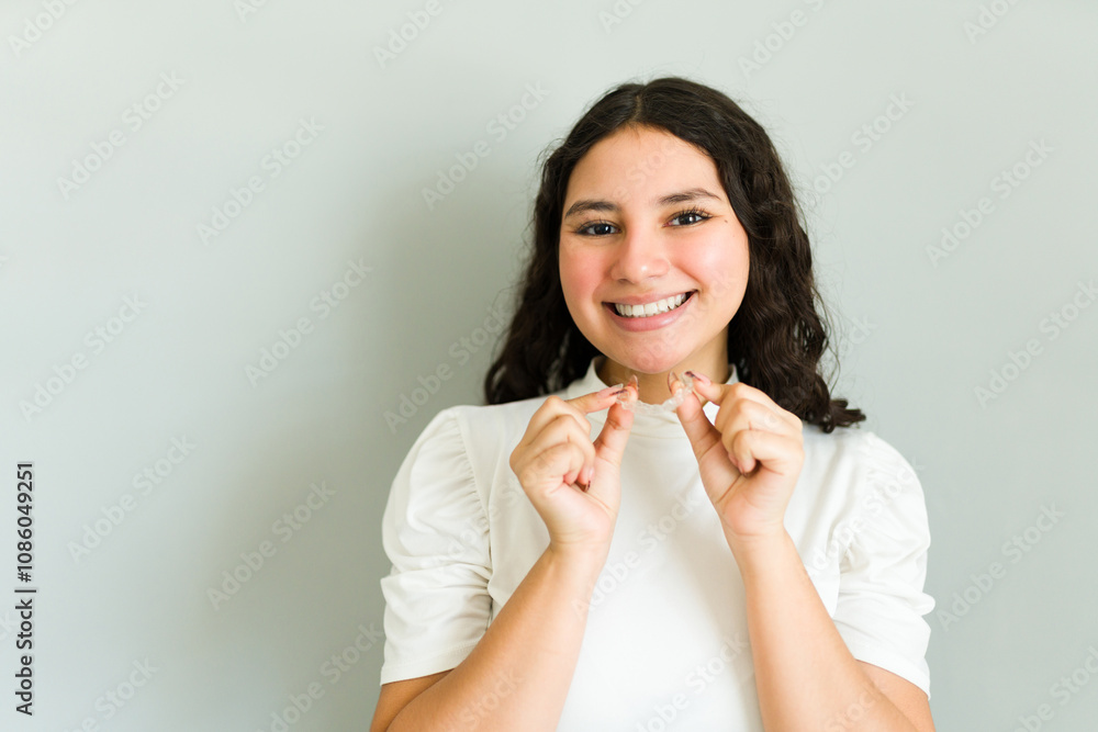 Portrait of a smiling teen girl showing her invisible braces, promoting orthodontic health and dental care for teenagers Portrait of a smiling teen girl showing her invisible braces, promoting orthodontic health and dental care for teenagers