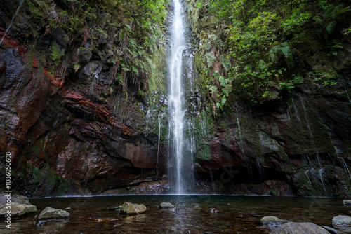 Beautiful waterfall in the middle of a jungle surrounded by foliage, shot in Madeira, Portugal