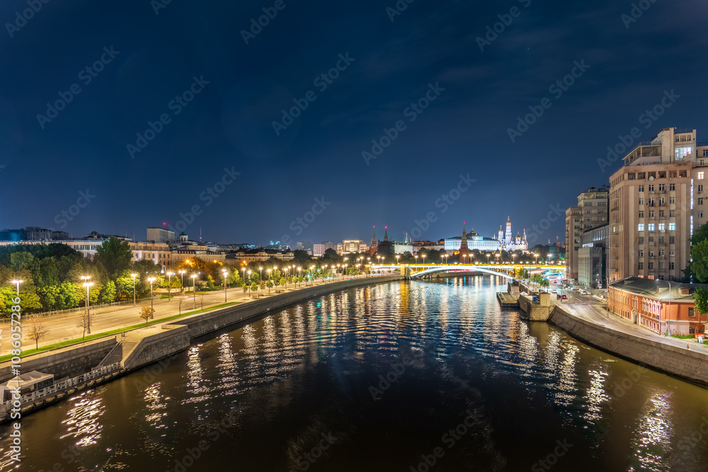 Fototapeta premium Illuminated Moscow Kremlin and Bolshoy Kamenny Bridge at summer night. View from the Patriarshy pedestrian Bridge