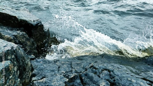 a large wave hits the rocks during a storm in slow motion