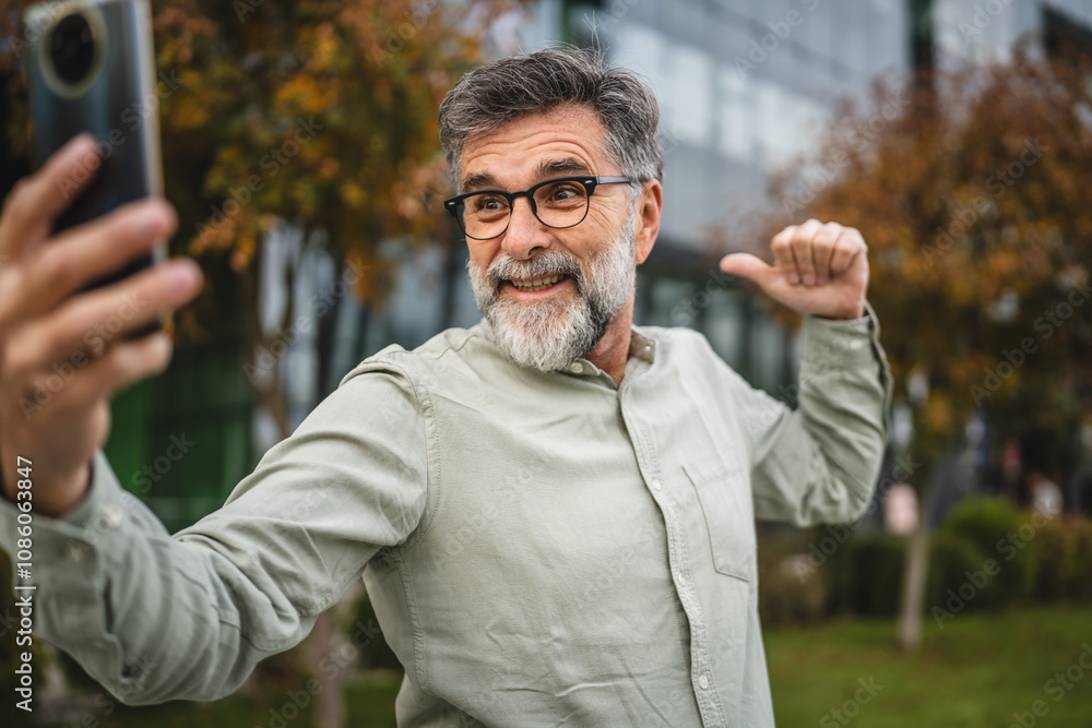 Obraz premium Senior man show building and exterior on video call