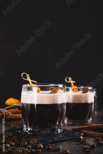 Spanish coffee cocktail with cinnamon and orange zest in glasses on table vertical view