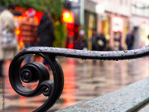 Canvas Print Bench metal hand in rain drops close-up during Christmas in Copenhagen city cent