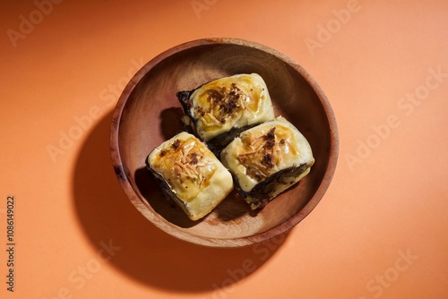 Banana bolen is made from banana and pastry skin and has chocolate and cheese filling. Served in wooden plate. Selective focus image. photo