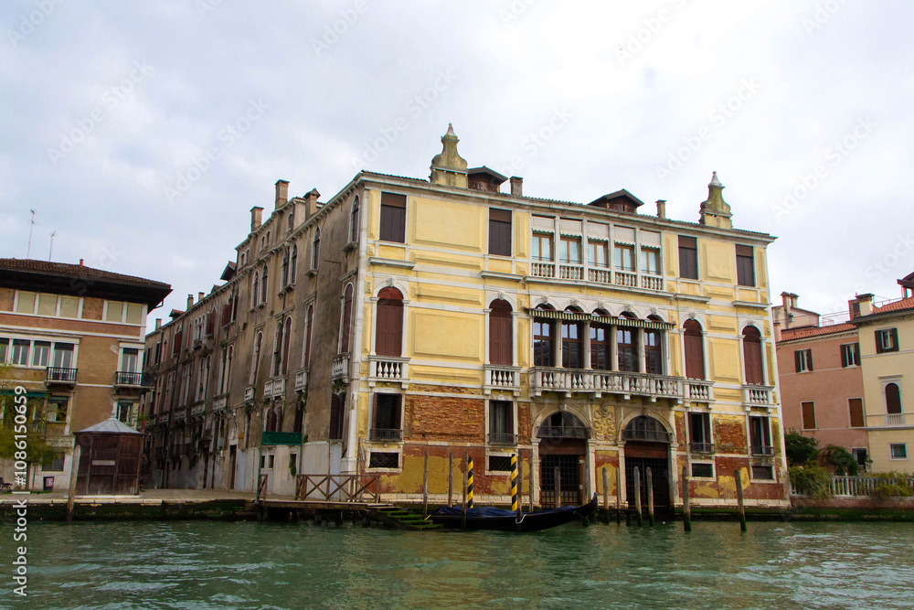 A view of historic Venetian buildings along the Grand Canal, showcasing classic Italian architecture. The iconic canal waters reflect the facades, with boats and gondolas adding to the charm of Venice A view of historic Venetian buildings along the Grand Canal, showcasing classic Italian architecture. The iconic canal waters reflect the facades, with boats and gondolas adding to the charm of Venice