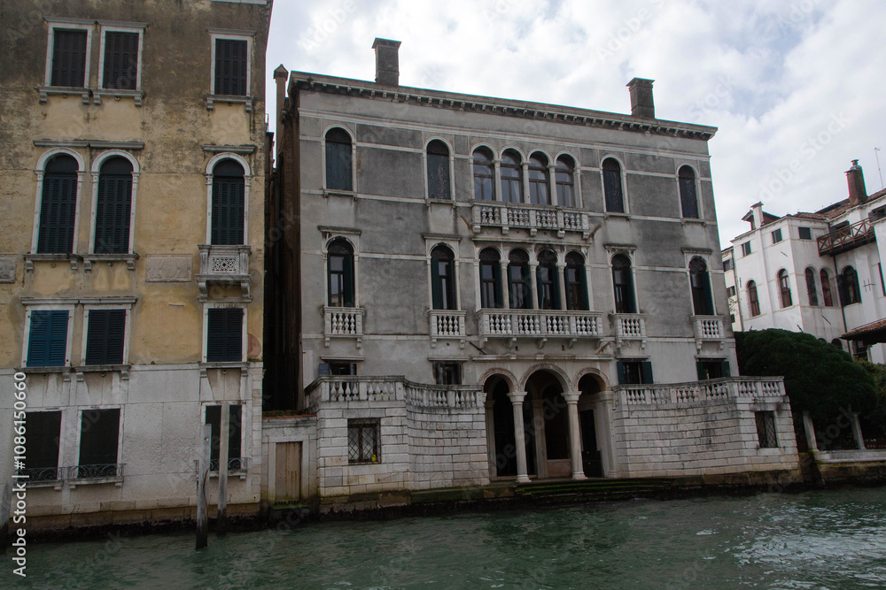A view of historic Venetian buildings along the Grand Canal, showcasing classic Italian architecture. The iconic canal waters reflect the facades, with boats and gondolas adding to the charm of Venice A view of historic Venetian buildings along the Grand Canal, showcasing classic Italian architecture. The iconic canal waters reflect the facades, with boats and gondolas adding to the charm of Venice