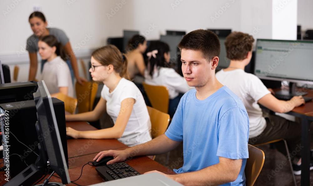 Concentrated schoolboy working with computers in classroom Concentrated schoolboy working with computers in classroom