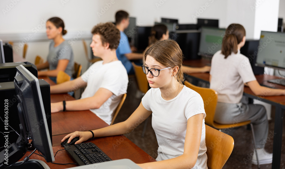 Clever female teenager wearing glasses and solving tasks of computer science in the auditory Clever female teenager wearing glasses and solving tasks of computer science in the auditory