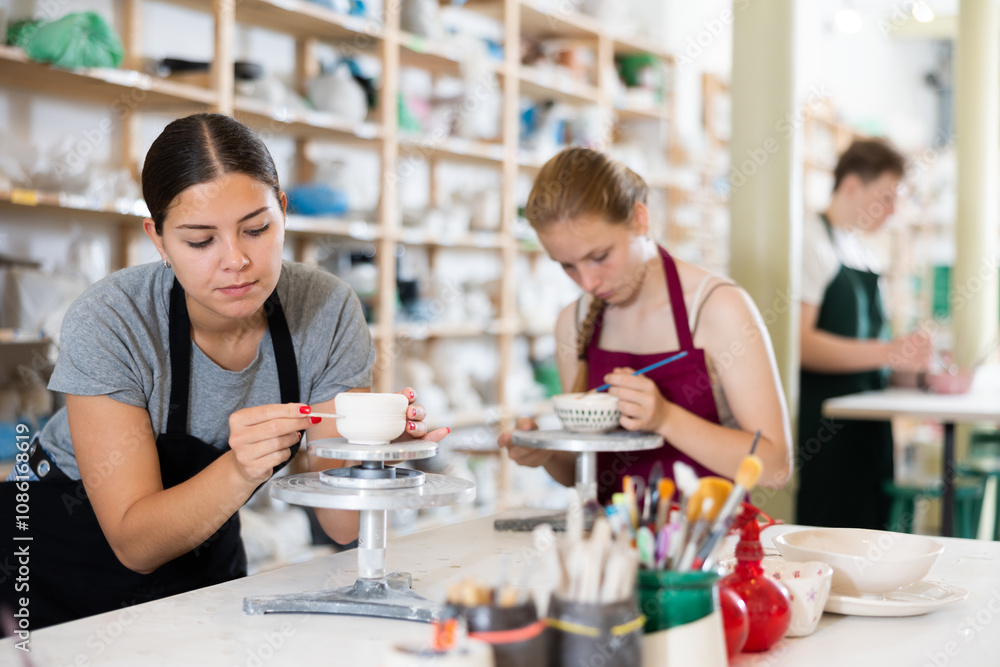 Teenagers are interested in making dishes from clay in a pottery workshop Teenagers are interested in making dishes from clay in a pottery workshop