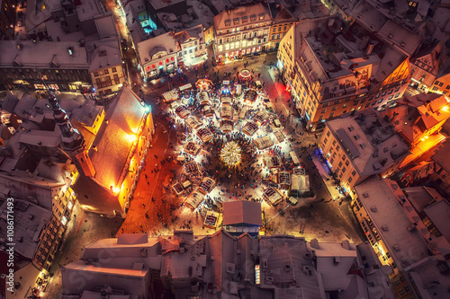 Fototapeta Aerial night View of Tallinn with the Town Hall Square in winter, roofs with sno