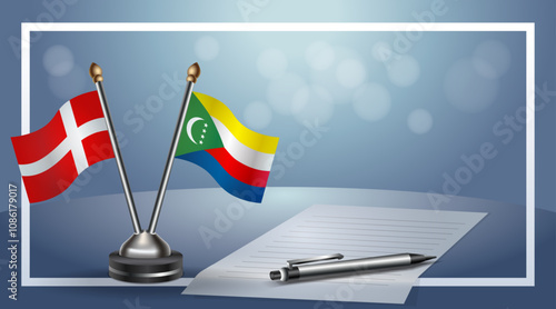 Denmark and Comoros National flags on small table with bokeh background, cooperative relationship