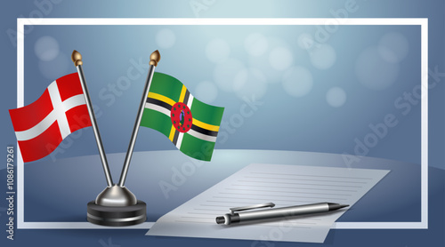Denmark and Dominica National flags on small table with bokeh background, cooperative relationship