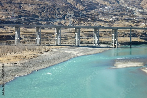 Canvas Print A scenic view of a Chinese built railway bridge spanning a turquoise river, set against the rugged landscape, connecting Lhasa and Shigatse in Tibet