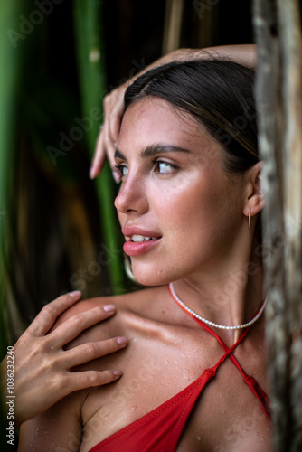 A Cheerful Smiling Woman Wearing an Orange Bikini Surrounded by Lush Greenery and Nature