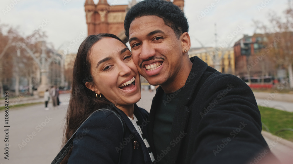 Happy couple taking selfie with city park and historical buildings in background Happy couple taking selfie with city park and historical buildings in background