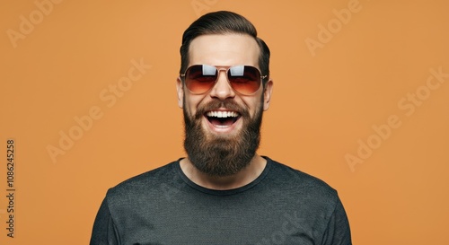 Bearded Caucasian male in sunglasses smiling with orange background