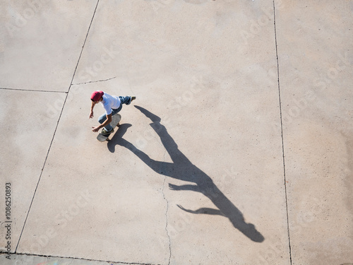 Fotografie Young skateboarder practicing in urban skatepark on sunny day