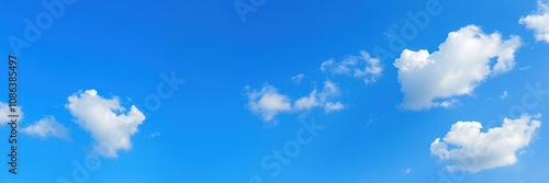 Fluffy white and cream-colored clouds scattered across a clear blue sky with subtle texture, texturedbackground, photo