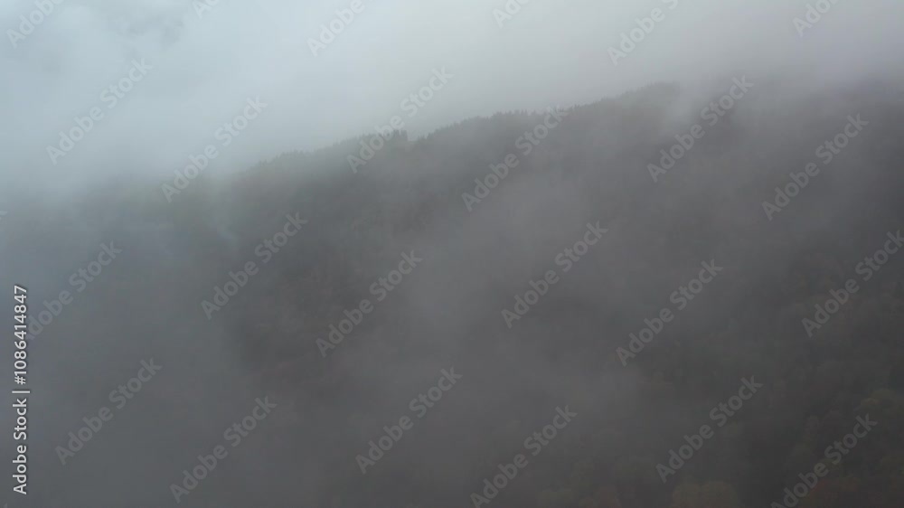 A drone flies through thick clouds, emerging to reveal a towering mountain peak surrounded by dramatic terrain. The transition highlights the scale and majesty of the hidden landscape A drone flies through thick clouds, emerging to reveal a towering mountain peak surrounded by dramatic terrain. The transition highlights the scale and majesty of the hidden landscape