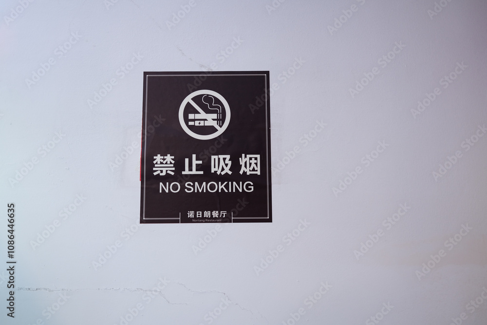 no smoking sign icon with Chinese and English word text hanging on the white wall at indoor area in China main land country no smoking sign icon with Chinese and English word text hanging on the white wall at indoor area in China main land country