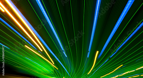 Εκτύπωση καμβά Green and blue light beams with golden streaks in a vibrant, abstract design