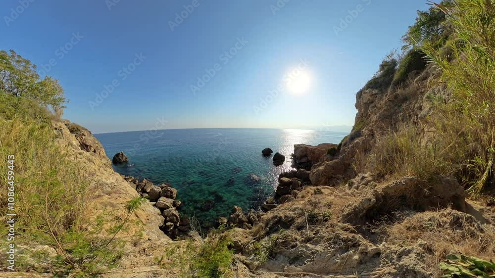 A rocky coastal view with cliffs and greenery overlooking the calm blue sea under a bright sun, showcasing a serene, panoramic coastal landscape. A rocky coastal view with cliffs and greenery overlooking the calm blue sea under a bright sun, showcasing a serene, panoramic coastal landscape.