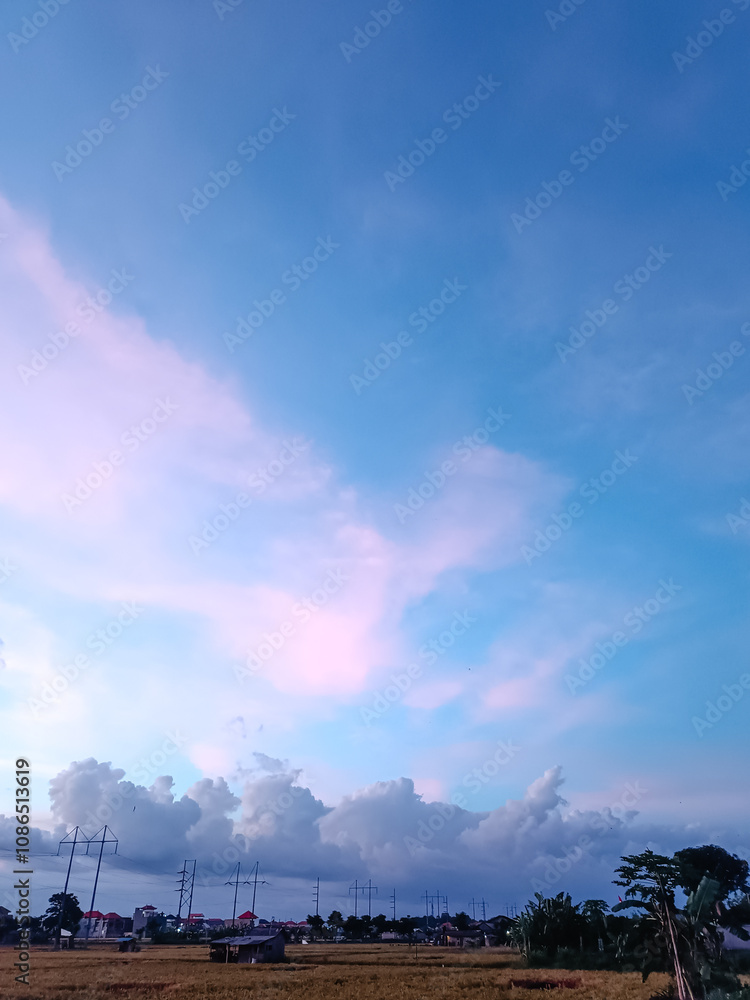 Colorful evening sky with pink clouds on the background of a field. Beautiful dark purple sky after sunset Colorful evening sky with pink clouds on the background of a field. Beautiful dark purple sky after sunset