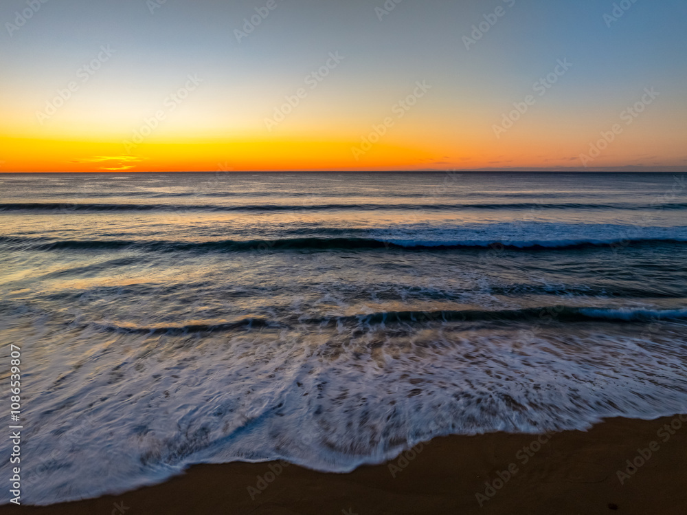 Sunrise at the seaside with clear skies and orange horizon Sunrise at the seaside with clear skies and orange horizon