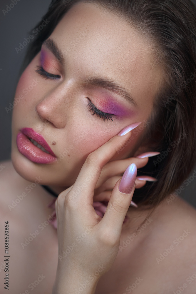 model is gently touching her face, highlighting her soft pink eyeshadow and glossy lips. Her long, manicured nails add an elegant touch, conveying confidence and beauty in a calm environment model is gently touching her face, highlighting her soft pink eyeshadow and glossy lips. Her long, manicured nails add an elegant touch, conveying confidence and beauty in a calm environment