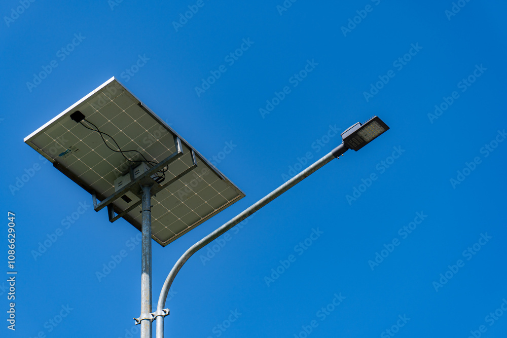The street light uses solar powered technology against the background of a clear blue sky