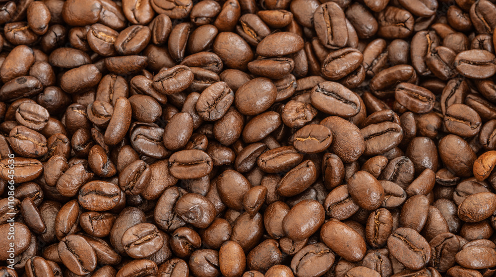 Obraz premium Close-up of roasted coffee beans, rich brown texture, ideal for coffee branding, food photography, and beverage industry visuals.