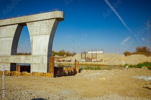 Huge pole in foundation with metal piles, construction of concrete-reinforced bridge pillars at building site photo