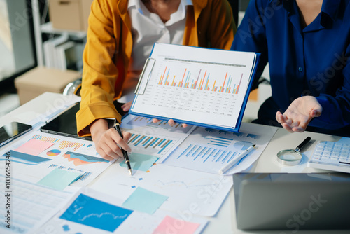 Business documents on office table with smart phone and calculator digital tablet and graph business with social network diagram