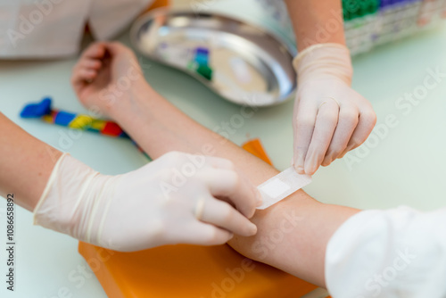 Quadro em tela Doctors bandaging child's arm post-treatment