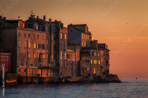 Obraz na płótnie Rovinj, Croatia - View of the beautiful ancient houses and walls of the Old Town of Rovinj on a hot summer afternoon with golden sky at sunset w salonie